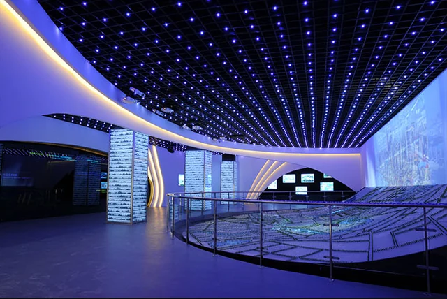 Blue-lit exhibition interior with a luminous ceiling
